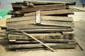 Old boards stand in heap. Broken planks lie on beach