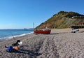 An old boat on the beach at Branscombe in Devon, England. Fishermen`s equipment stands in the foreground Royalty Free Stock Photo