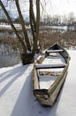 Old boat on lake coast covered with snow in winter Royalty Free Stock Photo