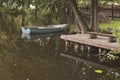 Old boat on the lake on the water next to a wooden bench a place of quiet summer recreation and fishing Royalty Free Stock Photo