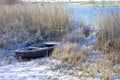 Old boat among reeds on the bank of a frozen river Royalty Free Stock Photo