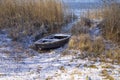 Old boat among reeds on the bank of a frozen river Royalty Free Stock Photo