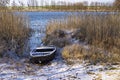 Old boat among reeds on the bank of a frozen river Royalty Free Stock Photo