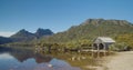the old boat shed at dove lake with cradle mt in the distance on a calm summer morning at cradle mountain national park Royalty Free Stock Photo