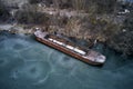 Old boat ship, trapped, frozen in winter ice lake, docked in pier, aerial top down view Royalty Free Stock Photo