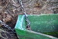 The old boat is tied to a tree trunk by a chain. Royalty Free Stock Photo