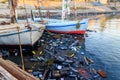 Old boats moored in dirty harbour. Pollution of river, sea, ocean water with waste, plastics garbage Royalty Free Stock Photo