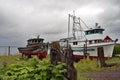 Old boats sitting on shore in a small Alaska town,