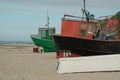 old boats stand on the beach by the sea.An old peeling fishing boat stands on the shore. A fishing net hangs on a boat Royalty Free Stock Photo