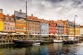 Old boats on the water in front of the colorful houses of the famous Nyhavn street in Copenhagen. Copenhagen, Denmark - 17/07/