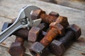 Old bolts with adjustable wrench tools on wooden background