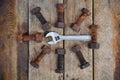 Old bolts with adjustable wrench tools on wooden background