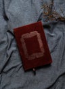 Old book cover in red canvas with embossed golden abstract decorations.