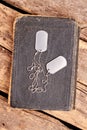 Old book and dog tags. Royalty Free Stock Photo