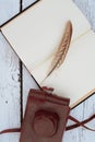Old book and feather pen on vintage white wooden table Royalty Free Stock Photo