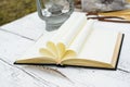 Old book and feather pen on vintage white wooden table Royalty Free Stock Photo