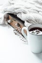 Old book with field flowers as bookmarks, knitted blanket and a cup of tea with mint leaves