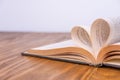 Old book and heart-shaped pages. White background. Wooden Table Royalty Free Stock Photo