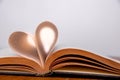 Old book and heart-shaped pages. White background. Wooden Table. Closeup. Copy space Royalty Free Stock Photo