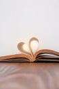 Old book and heart-shaped pages. White background. Wooden Table. Copy space Royalty Free Stock Photo