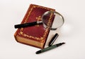 Old book,pen and magnifie Royalty Free Stock Photo