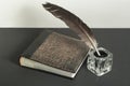 Old book and quill pen with inkwell on wooden table. Free copy space. Royalty Free Stock Photo