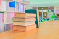 Old book red - green. heap are interior library school on wooden table and blurry bookshelves background. Royalty Free Stock Photo