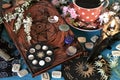 Old book of spells, flowers and runes on witch altar table.