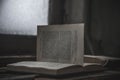 An old book with a torn page lies in an abandoned building. Gloomy atmosphere. An old book.