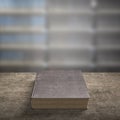 Old book on wooden table with blur bookshelfs background