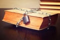 Old book wrapped with chain and locked on padlock on table