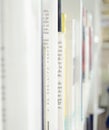 Old books blurred background. White paper books on the white shelf in the lightful room Royalty Free Stock Photo