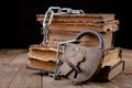 Old books bound by a new shiny chain with an old padlock. Forbidden old works artists on a wooden table Royalty Free Stock Photo