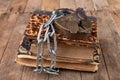 Old books bound by a new shiny chain with an old padlock. Forbidden old works artists on a wooden table Royalty Free Stock Photo