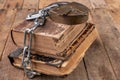 Old books bound by a new shiny chain with an old padlock. Forbidden old works artists on a wooden table Royalty Free Stock Photo