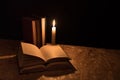 Old books and burning candle on a wooden table on a night Royalty Free Stock Photo