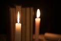 Old books and burning candle on a wooden table on a night Royalty Free Stock Photo