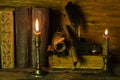 Old books,  burning candles and scrolls of documents lie on the table Royalty Free Stock Photo