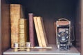Old books and a camera on a vintage shelf in the closet, close-up Royalty Free Stock Photo