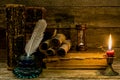 Old books and documents, a burning candle, hourglass and inkwell stand on a wooden surface Royalty Free Stock Photo