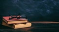 Old books and eye glasses on blackboard background Royalty Free Stock Photo