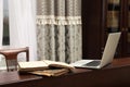 Old books and laptop on wooden table in library reading room Royalty Free Stock Photo