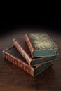 Old books piled on an antique wooden table