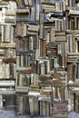 Old books piled on a wall, stacked in a disorderly fashion