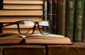 Old books and reading glasses on desk in library room Royalty Free Stock Photo