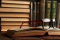 Old books and reading glasses on desk in library room Royalty Free Stock Photo