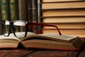 Old books and reading glasses on desk in library room Royalty Free Stock Photo