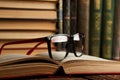 Old books and reading glasses on desk in library room Royalty Free Stock Photo