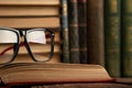 Old books and reading glasses on desk in library room Royalty Free Stock Photo