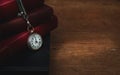 Old books stacked up on table with pocket watch  ,moody with room for text ,concept of time passsing Royalty Free Stock Photo